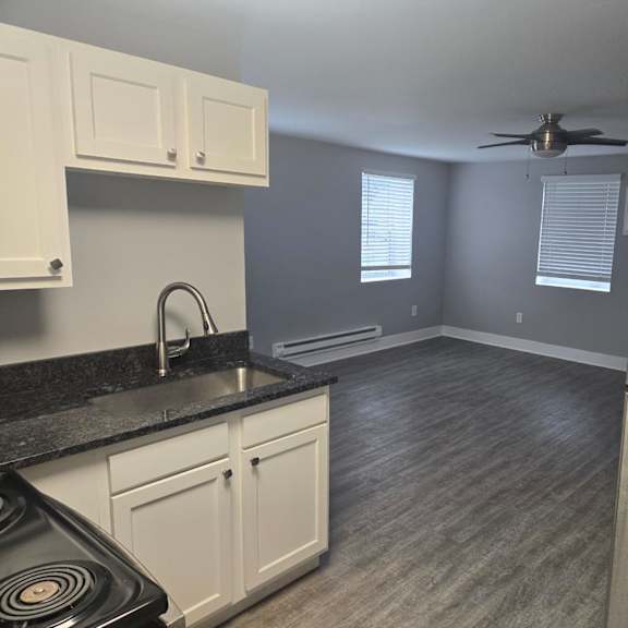 a kitchen with a black countertop and white cabinets.