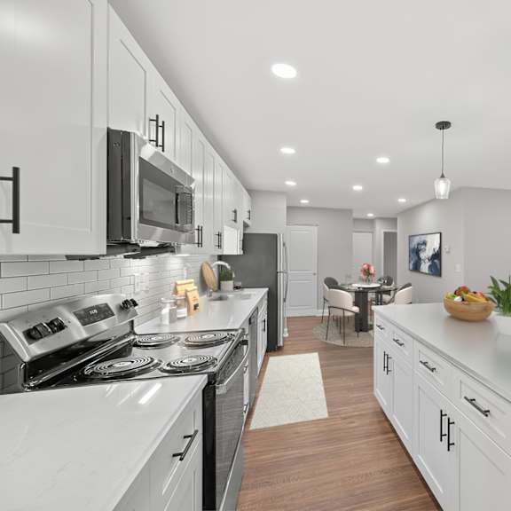 Thumbnail 4 of 18 A modern kitchen with white cabinets and a large island. at Indian Creek Apartments*, Cincinnati, Ohio