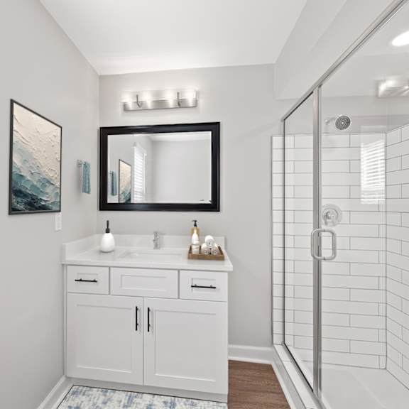 Thumbnail 14 of 25 A bathroom with a white cabinet and a large mirror above it. at Indian Creek Apartments*, Ohio