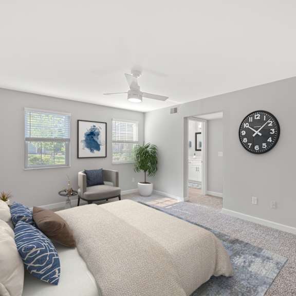 Thumbnail 10 of 25 A bedroom with a bed, pillows, a ceiling fan, a chair, a potted plant, and a clock on the wall. at Indian Creek Apartments*, Cincinnati, OH