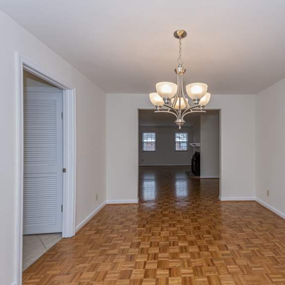 Thumbnail 9 of 22 Empty living room with a chandelier and a door to a room with at Indian Creek Apartments, Cincinnati, OH