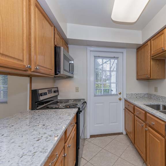 Thumbnail 3 of 22 Kitchen with granite counter tops and wooden cabinets at Indian Creek Apartments*, Ohio, 45236