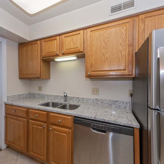 Thumbnail 4 of 22 Kitchen with wooden cabinets and stainless steel appliances and granite counter tops at Indian Creek Apartments, Ohio, 45236