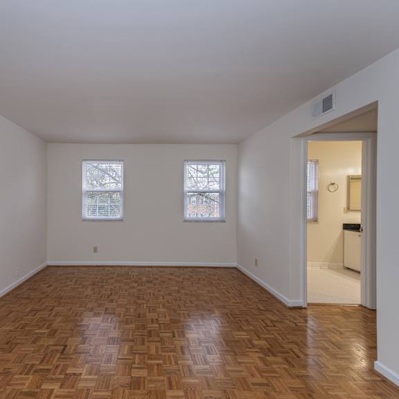 Thumbnail 15 of 22 Empty living room with wood flooring and two windows at Indian Creek Apartments*, Ohio, 45236