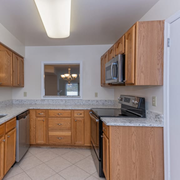 Thumbnail 6 of 21 a kitchen with wooden cabinets and granite counter tops and a sink at Indian Creek Apartments*, Cincinnati