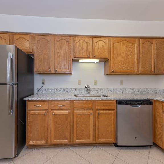 Thumbnail 5 of 21 a kitchen with wooden cabinets and a stainless steel refrigerator at Indian Creek Apartments*, Ohio