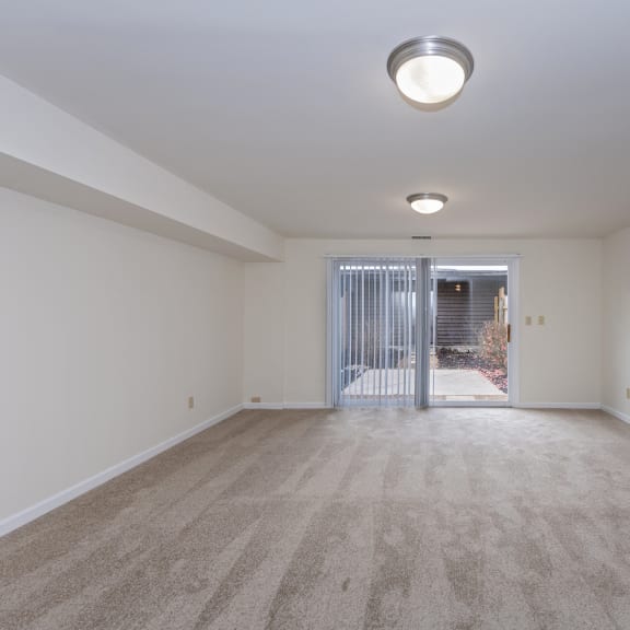 Thumbnail 15 of 21 a spacious living room with white walls and carpeting and a door to a balcony at Indian Creek Apartments*, Cincinnati, Ohio