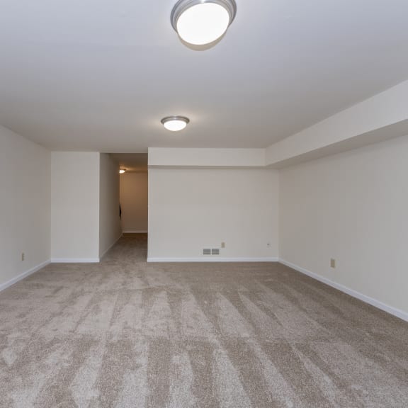 Thumbnail 14 of 21 an empty living room with carpet and white walls at Indian Creek Apartments*, Ohio