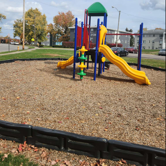 a playground in a park with a slide and other toys