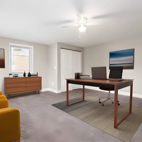 a living room with a couch and a desk with a laptop