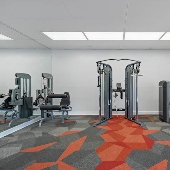 a gym with a variety of equipment including a leg press machine.