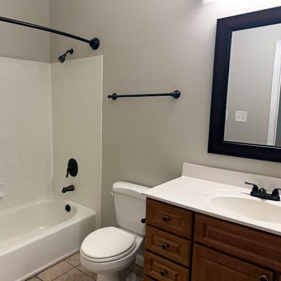 Thumbnail 9 of 10 A white toilet sits next to a white sink in a bathroom.