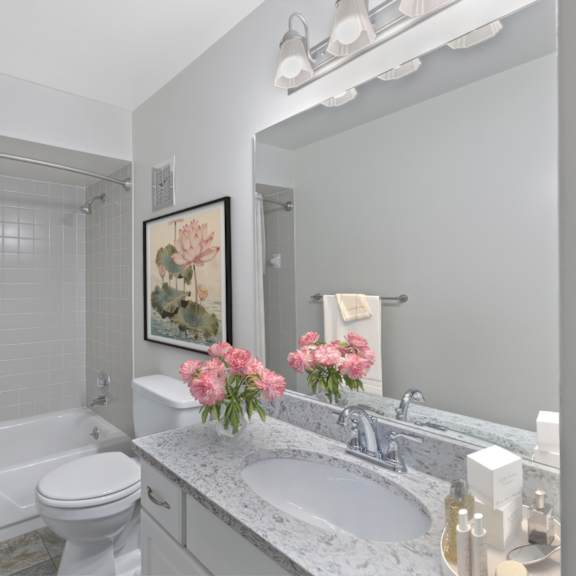 Thumbnail 10 of 12 A white bathroom with a toilet, sink, and shower.