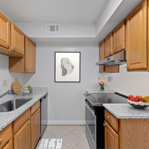 Thumbnail 5 of 12 A kitchen with wooden cabinets and a fridge.