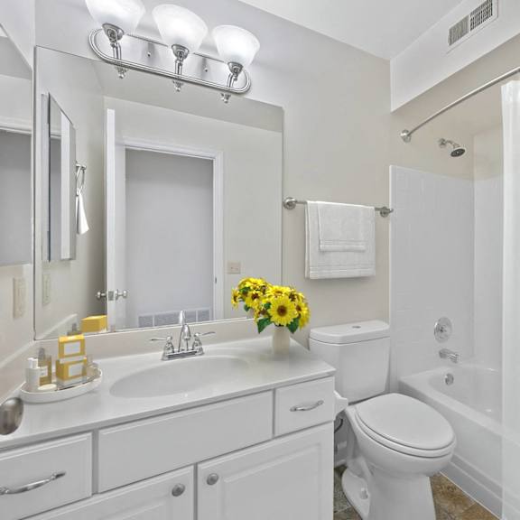 Thumbnail 9 of 10 A white bathroom with a sink, mirror, toilet, and shower. at Indian Creek Apartments*, Cincinnati