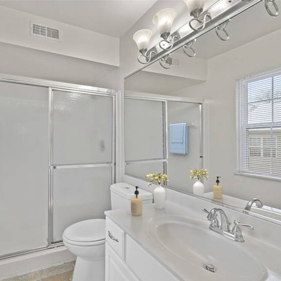 Thumbnail 8 of 10 A white bathroom with a toilet, sink, and shower. at Indian Creek Apartments*, Cincinnati, OH, 45236