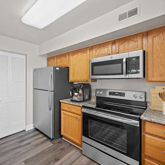 Thumbnail 3 of 10 A kitchen with wooden cabinets and stainless steel appliances. at Indian Creek Apartments*, Cincinnati, OH