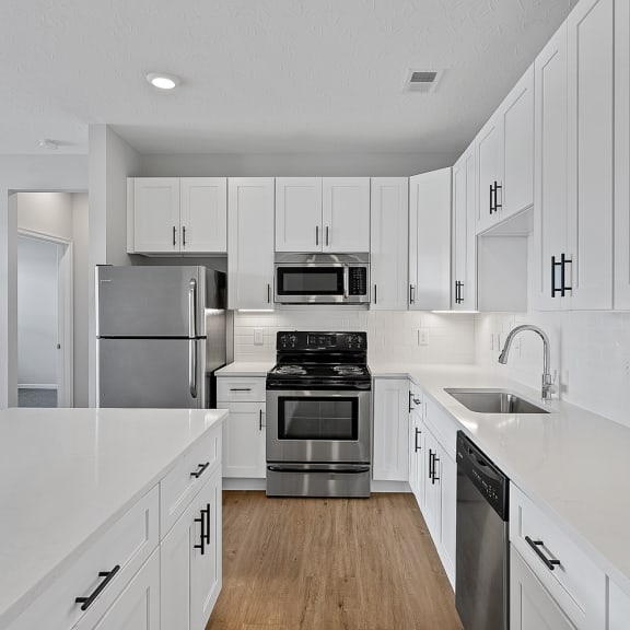 Thumbnail 3 of 19 a large white kitchen with white cabinets and stainless steel appliances at Monmouth Row Apartments, Newport, Kentucky