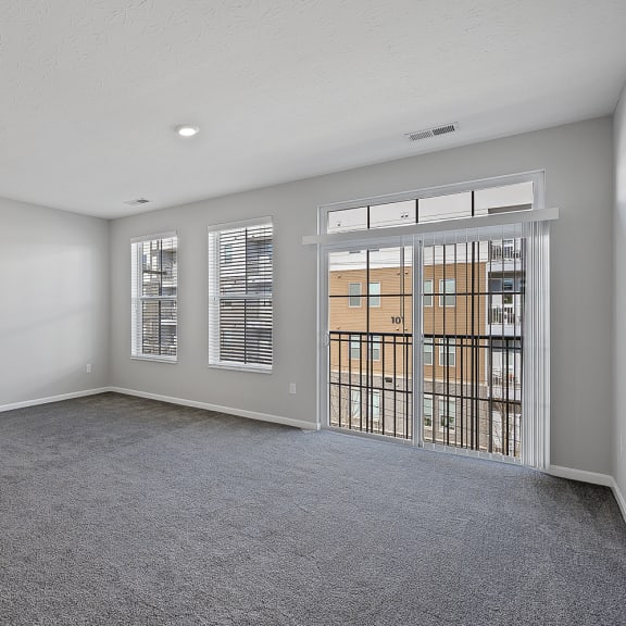 Thumbnail 12 of 19 an empty living room with a door to a balcony at Monmouth Row Apartments, Kentucky