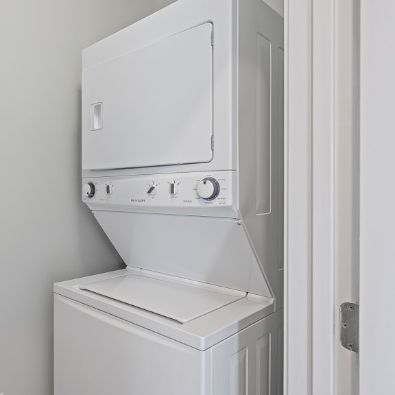 Thumbnail 19 of 19 a white washer and dryer in a white laundry room with a white door at Monmouth Row Apartments, Newport, 41071