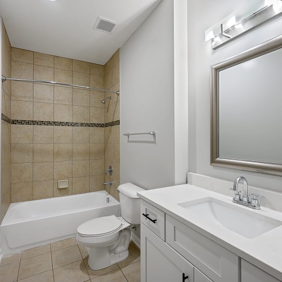 Thumbnail 17 of 19 a bathroom with a sink toilet and tub and a mirror at Monmouth Row Apartments, Newport, KY, 41071