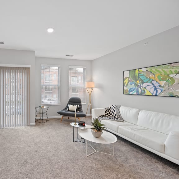 Thumbnail 7 of 15 an open living room with a white couch and a television at Monmouth Row Apartments, Newport, KY