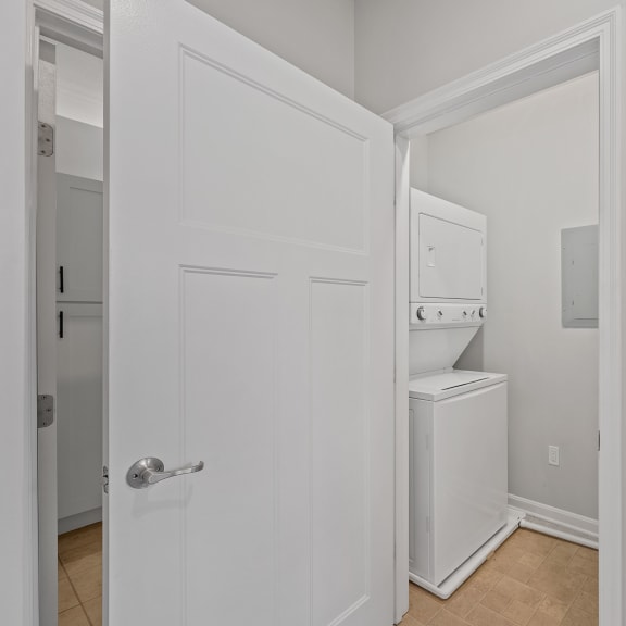 Thumbnail 14 of 15 a laundry room with a washer and dryer and a white door at Monmouth Row Apartments, Newport, 41071
