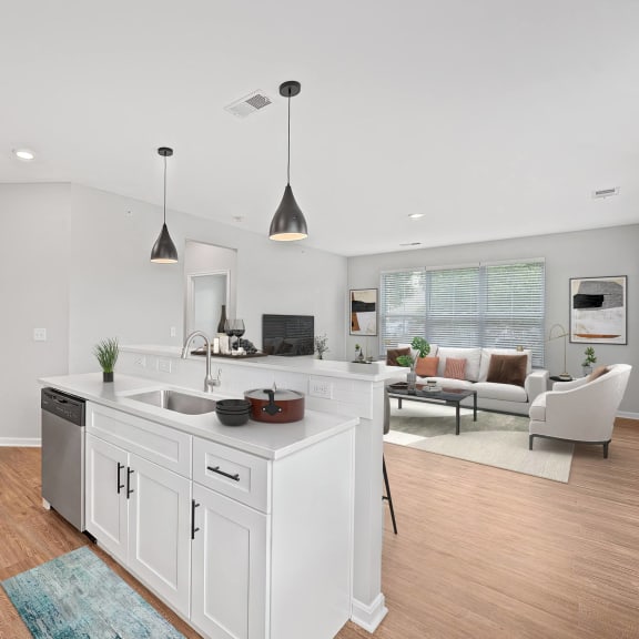 Thumbnail 3 of 7 a white kitchen with an island and a living room at Monmouth Row Apartments, Newport, KY