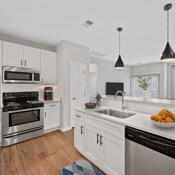 Thumbnail 4 of 8 a white kitchen with a large counter top and a sink at Monmouth Row Apartments, Newport, 41071