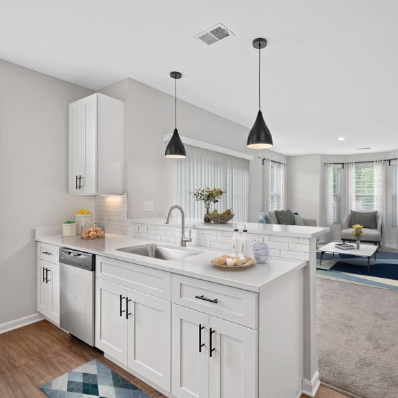 Thumbnail 3 of 6 an open kitchen and living room with white cabinets and a white counter top at Monmouth Row Apartments, Newport