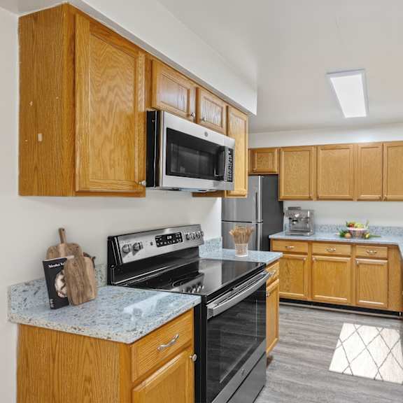 Thumbnail 6 of 10 A kitchen with wooden cabinets and granite countertops. at Indian Creek Apartments*, Ohio, 45236