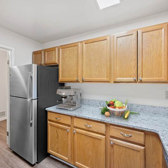 Thumbnail 5 of 10 A kitchen with wooden cabinets and a marble countertop. at Indian Creek Apartments*, Ohio, 45236