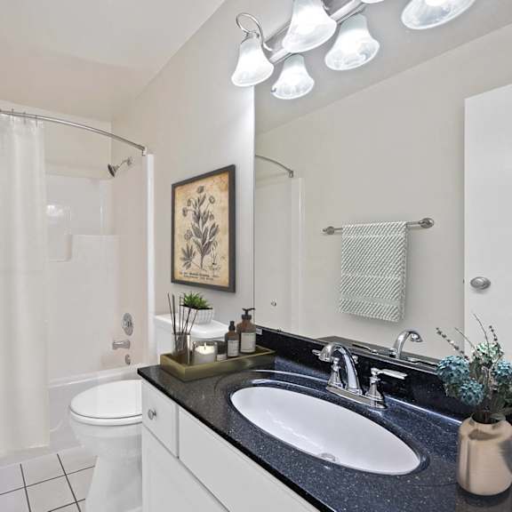Thumbnail 9 of 10 A bathroom with a white toilet, sink, and shower curtain. at Indian Creek Apartments*, Cincinnati