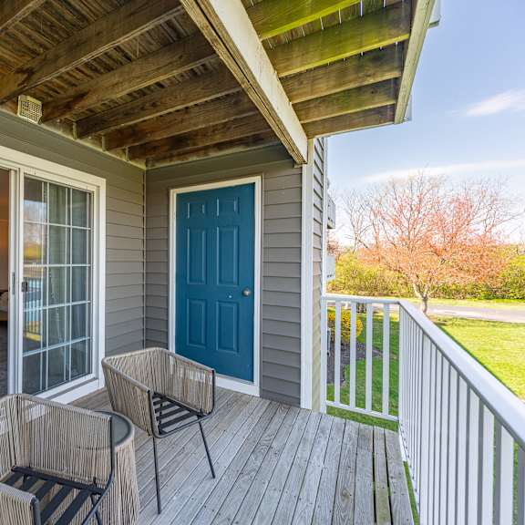 covered porch with two chairs and a blue door at wrights point, ft wright