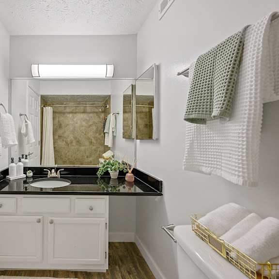 white bathroom with a black counter top and a mirror at wrights point, 41011