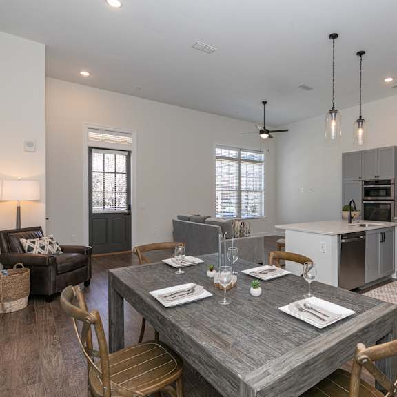 Thumbnail 3 of 8 A modern dining room with a wooden table set for two.
