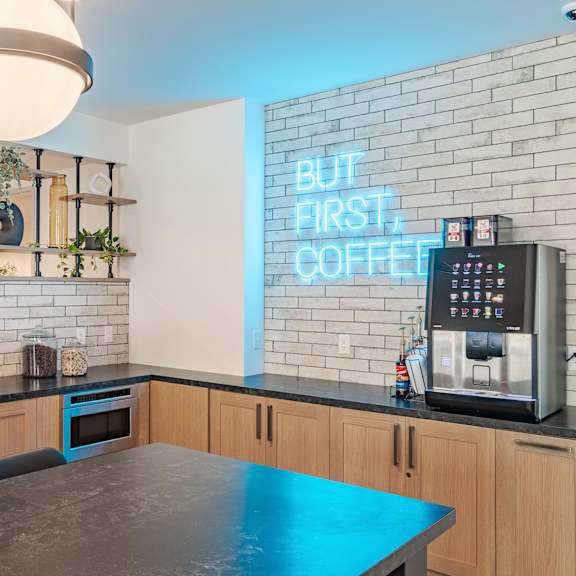 community kitchen with neon coffee sign and appliances at the yancey apartments, charlotte, nc