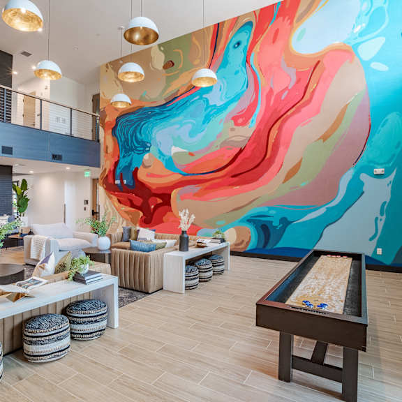 vibrant clubhouse lounge with colorful abstract wall mural at the yancey apartments, north carolina, 28217