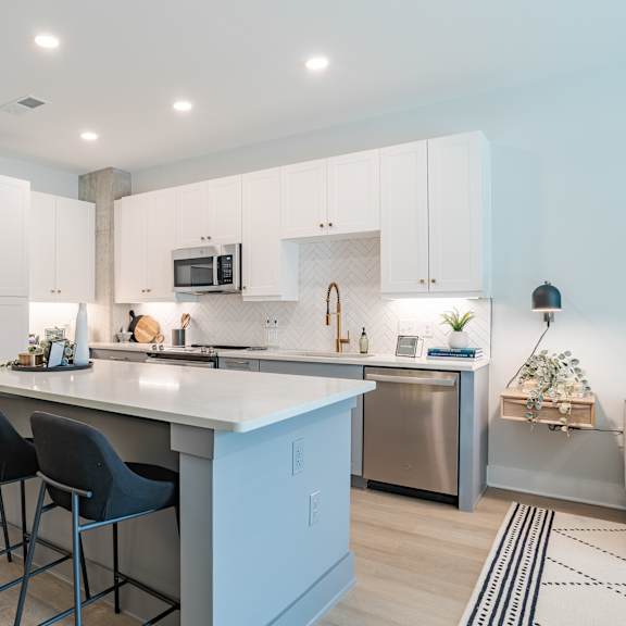 modern kitchen with white cabinets and island seating at the yancey apartments, charlotte, north carolina