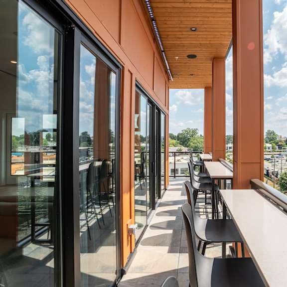 covered balcony seating with panoramic city views at the yancey apartments, charlotte, nc 28217