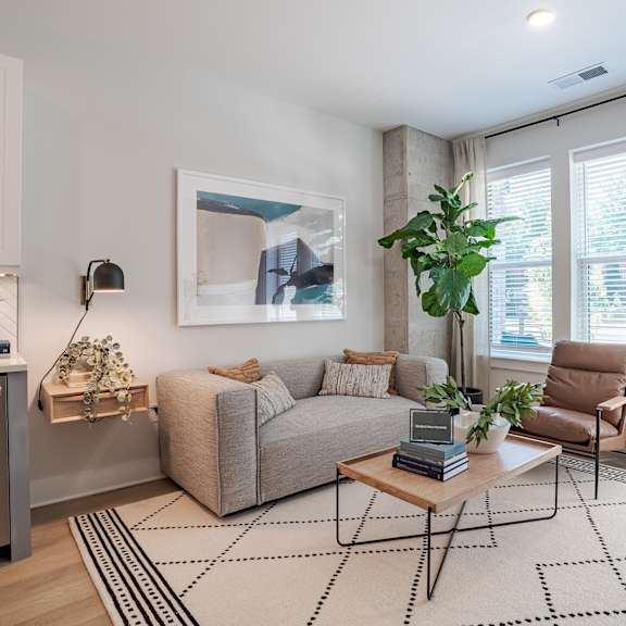 living room with modern furniture and area rug at the yancey apartments, north carolina, 28217