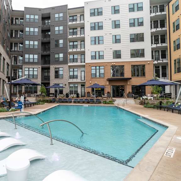resort style pool with sun shelf loungers and courtyard seating at the yancey apartments, north carolina