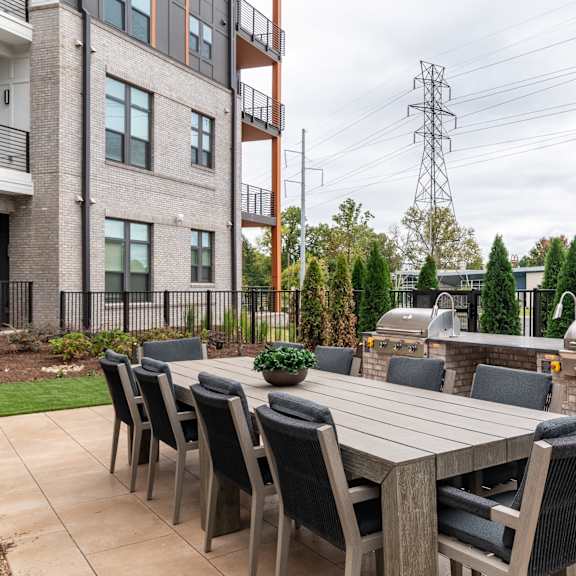 outdoor dining patio with builtin grills and seating at the yancey apartments, north carolina, 28217