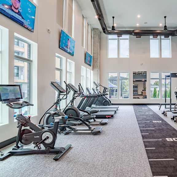 fitness center with cardio machines and weight training area at the yancey apartments, north carolina, 28217