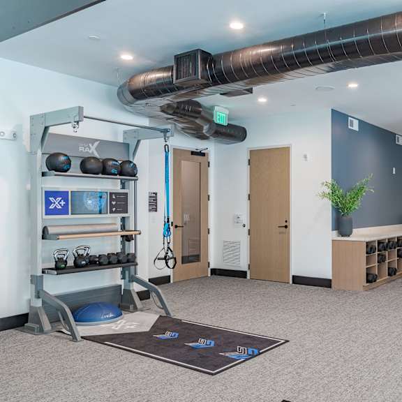 functional training studio with equipment racks and wall storage at the yancey apartments, north carolina