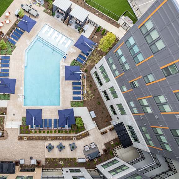 aerial view of pool deck with lounge chairs and cabanas at the yancey apartments, charlotte, nc