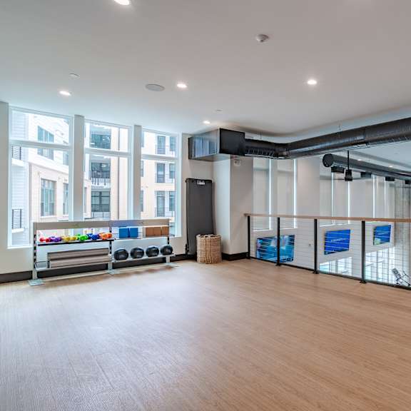 upper level fitness area with cable railing and exposed ductwork at the yancey apartments, north carolina