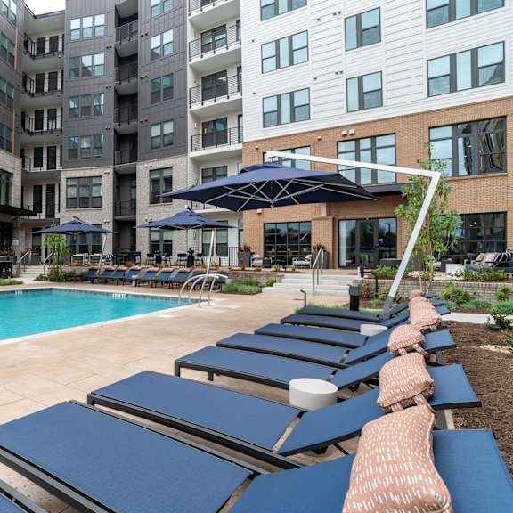 poolside lounge area with navy blue chaise chairs at the yancey apartments, charlotte, 28217