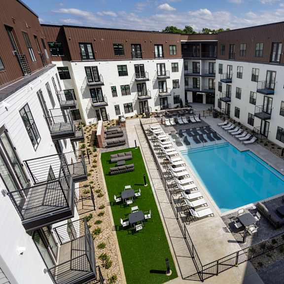 a large outdoor pool surrounded by lounge chairs and umbrellas.
