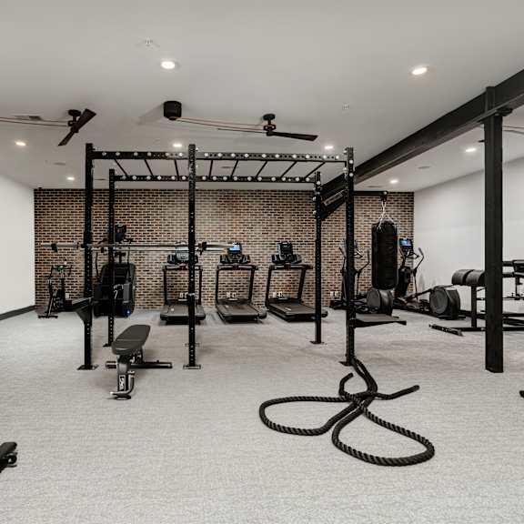a gym with a variety of equipment including weights and a bench.